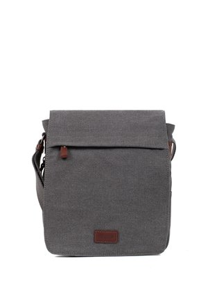 Sac bandoulière en tissu gris avec rabat avant, petite tirette de fermeture éclair en cuir marron et patch logo, bandoulière réglable visible sur les côtés.