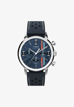 Kronografur med en marineblå skive, sølvfarvet urkasse og perforeret læderrem. Funktionen inkluderer flere undermålere og farvede striber.