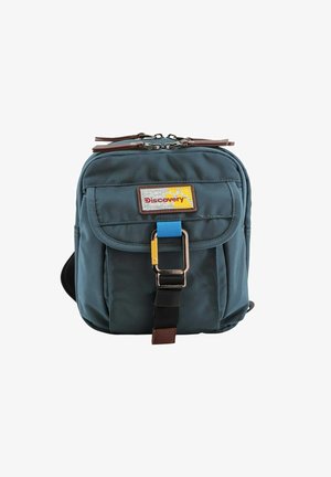 Blaue Stoff-Crossbody-Tasche mit braunem Lederakzent, Reißverschluss, verstellbarem Tragegurt, Vordertasche mit Klappe und einem Logoschild.