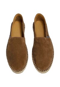 Scarpe slip-on in suede marrone con punta arrotondata, cuciture bianche a contrasto e suola texturizzata. L'interno presenta una finitura liscia color beige.