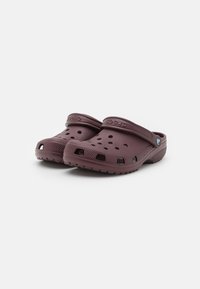 Mauve klompe s ventilacijskim otvorima, zaobljenim vrhom i trakama za petu. Izrađene su od laganog pjenastog materijala s teksturiranim potplatima za bolje prianjanje.