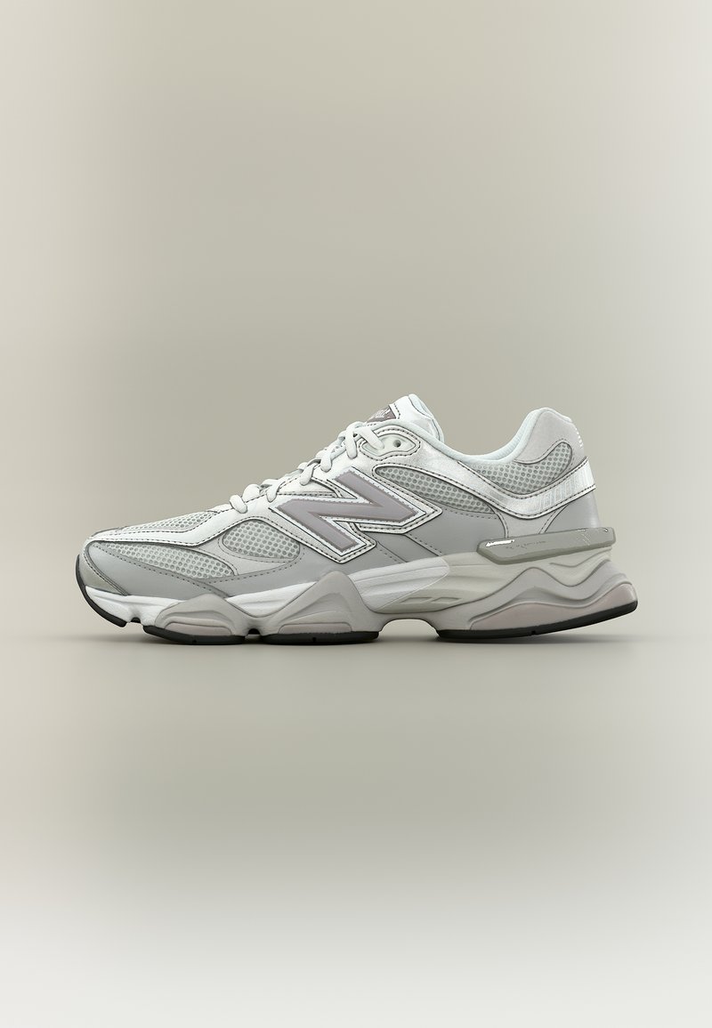 Γκρι και λευκό αθλητικό παπούτσι New Balance με πάνελ από δίχτυ και μαλακή σόλα, εμφανιζόμενο από το πλάι σε ουδέτερο φόντο.