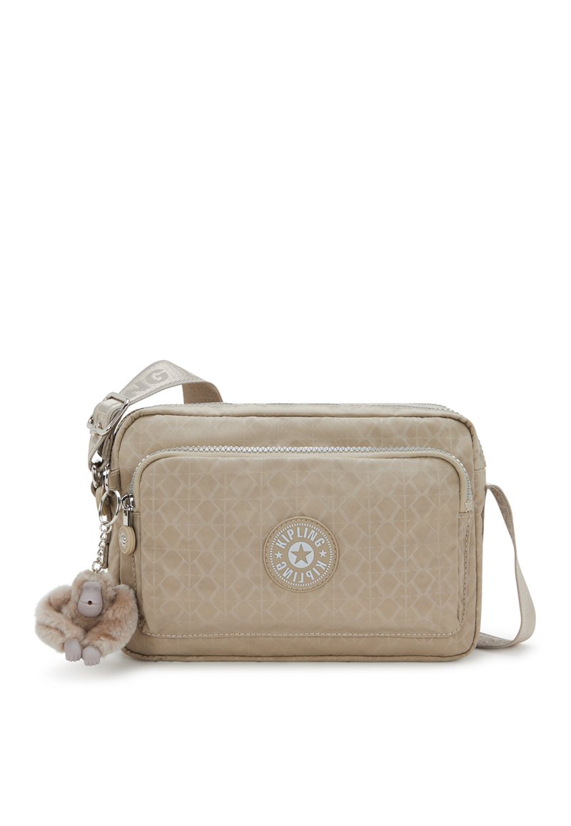 Beige crossbody bag made of textured fabric, featuring a zippered compartment, logo patch, and a fur-lined monkey keychain accent.