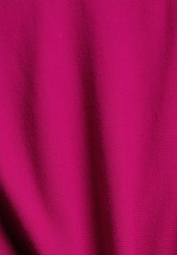 Bright magenta fabric with fine knit texture and subtle folds creating soft shadows.