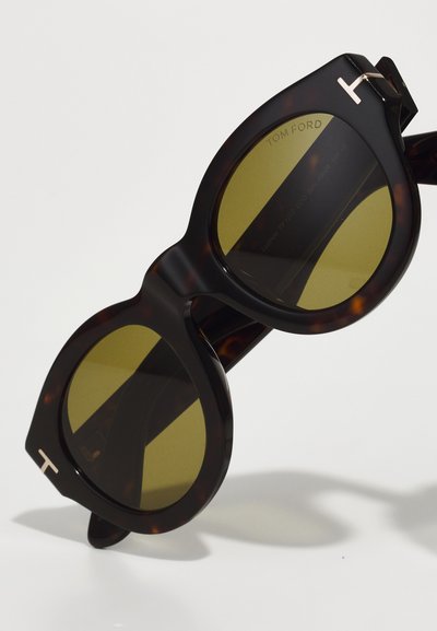 Ochelari de soare cu model țestoasă, cu lentile colorate în galben, formă supradimensionată și rotundă, accent metalic cu logo-ul „T” pe ramă.