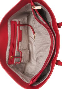 Rode leren handtas met een gestructureerde buitenkant. Het interieur heeft een beige gestreepte voering, meerdere compartimenten en een ritsvak.