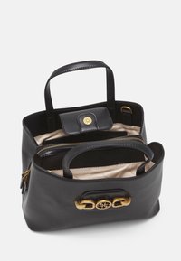 Černá kožená kabelka se zlatými kovovými doplňky, dvojitými uchy, kapsou na zip a zapínáním na patentku. Interiér má béžovou podšívku a několik přihrádek.
