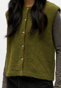 Zelený pletený svetr s knoflíky ve zlatém odstínu, strukturovanou tkaninou a zkráceným střihem. Má kulatý výstřih a detaily na ramenních švech.