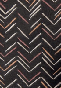 Textiel met een zwarte achtergrond en een herhaald chevronpatroon in witte, roze en oranje lijnen, wat een gestructureerde uitstraling creëert.