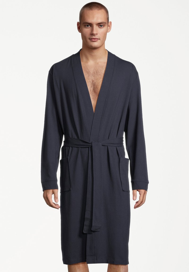 Ciemnogranatowy szlafrok wykonany z miękkiego materiału, z długimi rękawami, głębokim dekoltem w serek, paskiem w talii oraz dwiema przednimi kieszeniami.