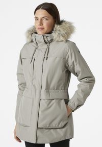 Light gray parka with a fur-lined hood, zippered front, two large front pockets, and a fitted waist for a structured silhouette.