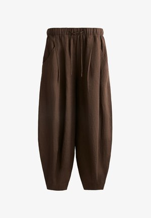 Bruine, loszittende broeken met een elastische tailleband, gemaakt van een gestructureerde stof, met zijzakken en taps toelopende boorden.