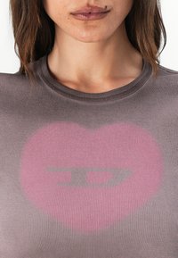 Grey ribbed t-shirt featuring a faded pink heart graphic with a darkened arrow shape at the center, round neckline, and snug fit.