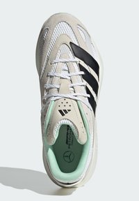 Buty sportowe z fakturowanym kremowo-białym wierzchem, czarnymi paskami, miętowymi akcentami oraz wyściółką amortyzującą. Posiadają przewiewny fason.