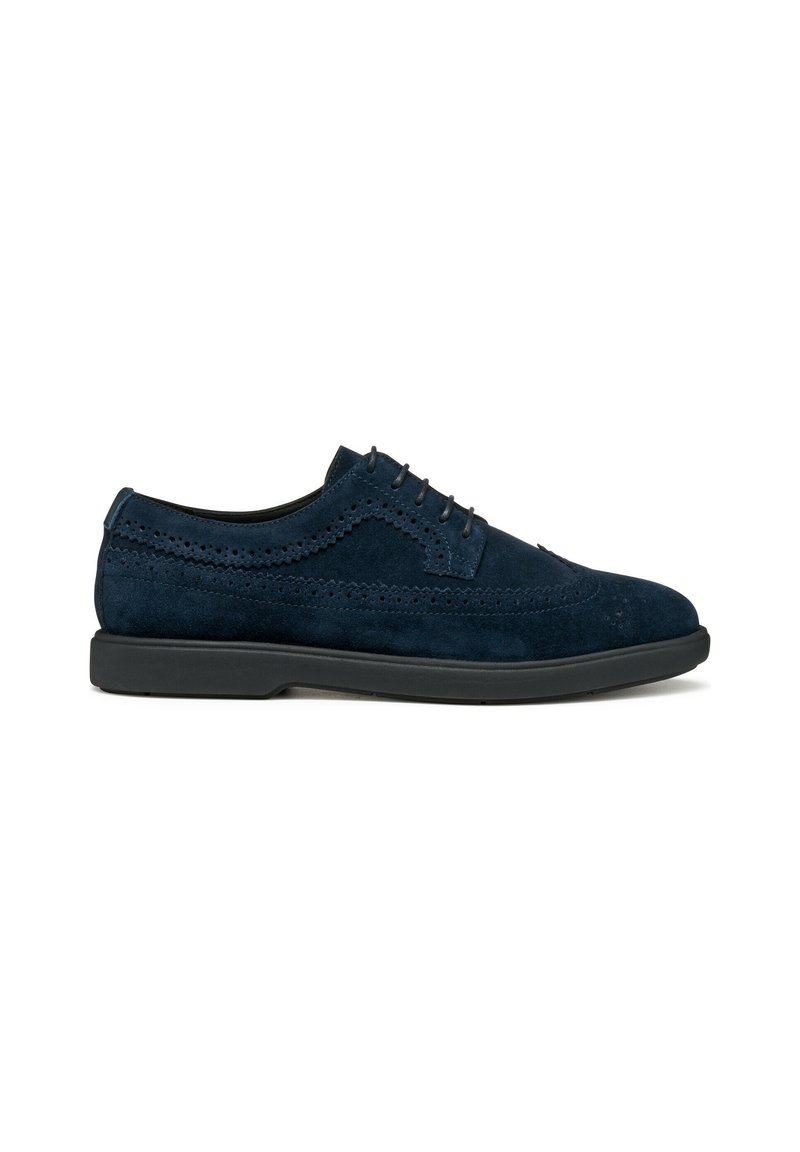 Scarpe in suede blu navy con dettagli brogue, design con lacci e suola in gomma nera. Presentano una texture liscia e accenti eleganti.