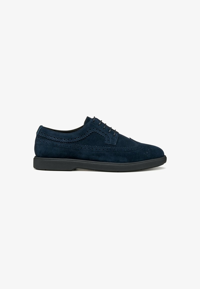Scarpe in suede blu navy con dettagli brogue, design con lacci e suola in gomma nera. Presentano una texture liscia e accenti eleganti.