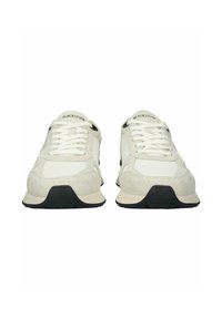 Białe skórzane i siatkowe sneakersy z czarną gumową podeszwą, z okrągłym noskiem, sznurowanym przodem i logo "BLACKSTONE" na języku.