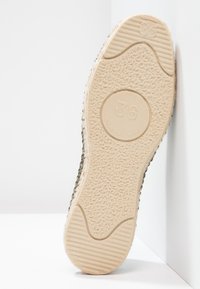 Rubber shoe sole in beige with textured grip, featuring size "36" embossed. The edge has a woven fabric accent in green tones.