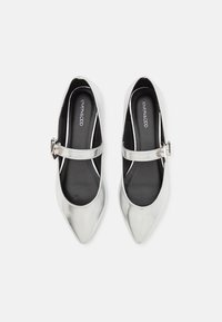 Ballerine metalliche argento con punta affusolata e una cinghia con fibbia. Fodera interna nera e design minimalista.