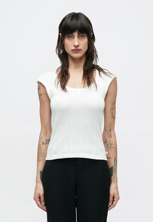 Top bianco in maglia a coste con scollo a girocollo e maniche corte. Presenta una silhouette aderente e un orlo dritto. Nessun motivo o dettaglio visibile.
