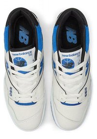 White sneakers with blue and black accents, featuring a smooth leather upper, padded collar, and a flat rubber sole. "New Balance 550" printed on side.