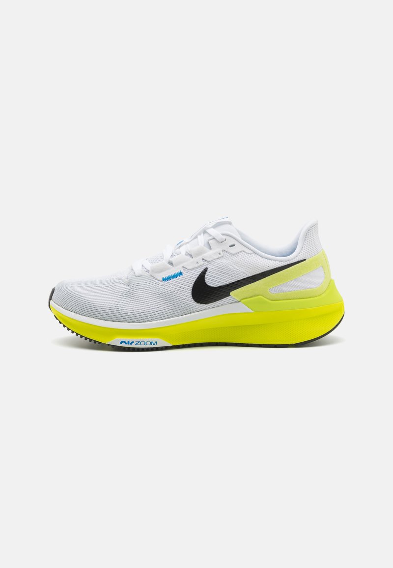 Baskets de course blanches Nike avec un dessus en maillage respirant, un logo noir, une semelle intermédiaire jaune et une semelle extérieure texturée portant la marque "Air Zoom".