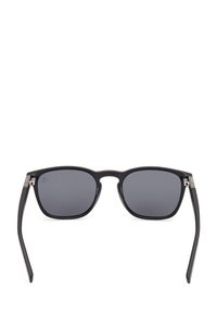 Czarne kwadratowe okulary przeciwsłoneczne z ciemnoszarymi soczewkami, matowe wykończenie i metalowe akcenty na zawiasach. Prosty, nowoczesny design z prostymi ramionami.