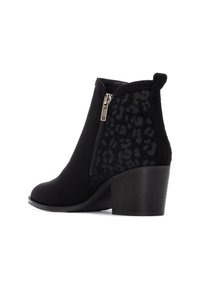 Botas negras de tobillo con un exterior de ante suave, un panel lateral con estampado de leopardo, cremallera lateral y un tacón apilado.