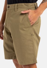 Shorts kaki en tissu de coton, avec une poche avant et une fermeture à bouton, dotés d'une coupe droite et d'un ourlet cousu.