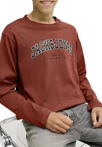 Chemise à manches longues en teinte rouille avec un graphisme "JACK&JONES" en noir, fabriquée en tissu doux, avec une coupe décontractée et un col rond.