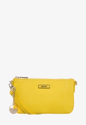 Pochette DKNY jaune vif avec surface texturée, fermeture éclair argentée et breloque ronde en argent avec le logo DKNY sur fond blanc.