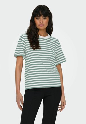 Stribet t-shirt i grøn og hvid, lavet af bomuldsstof, korte ærmer, rundt halsudskæring, afslappet pasform, parret med sorte bukser. Ingen bemærkelsesværdige mønstre eller accenter.