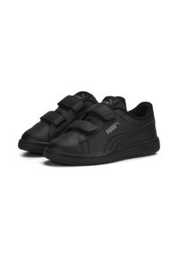 Chaussures de sport noires avec deux bandes Velcro ajustables, en matériau synthétique lisse, bout arrondi et accents de logo en relief sur les côtés.