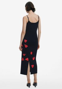 Fekete midi ruha piros virágmintával, állítható pántokkal és oldalsó hasítékkal. Simább anyagból készült, testhezálló fazonban.