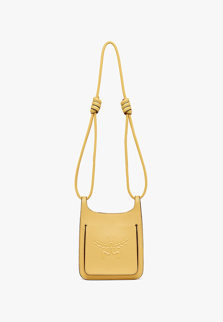 Gelbe Leder-Crossbody-Tasche mit geprägtem Logo, verstellbarem geknotetem Tragegurt und kontrastierenden Besätzen. Glatte Textur und minimalistisches Design.