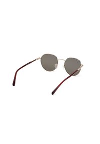 Lunettes de soleil rondes en métal avec verres gris, monture dorée et branches accentuées de bourgogne. Équipées de plaquettes de nez pour le confort et d'un design élégant.