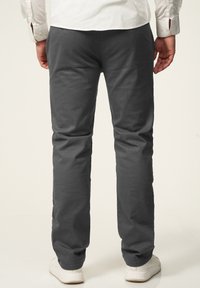 Gray cotton pants with a straight-leg design, featuring a smooth texture and back pocket detail, paired with white sneakers.