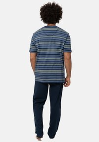 Gestreepte t-shirt in marineblauwe en groene tinten, gecombineerd met donkerblauwe broek; zachte katoen stof; relaxte pasvorm; korte mouwen zonder zichtbare logo's.