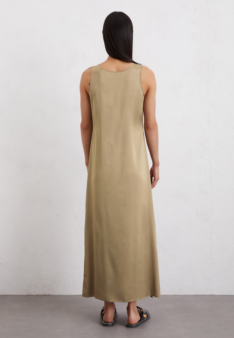 Elegantes, bodenlanges olivgrünes Kleid mit rundem Ausschnitt und ärmellosem Design, aus einem glatten, leichten Stoff gefertigt. Sichtbare schwarze Sandalen.