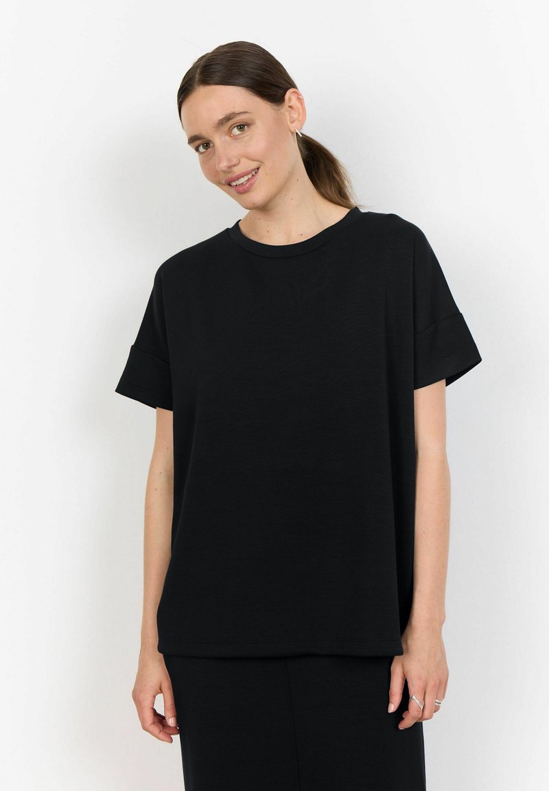 Svart kortärmad t-shirt i avslappnad passform, tillverkad av mjukt tyg med rundad halsringning och uppvikta ärmar, uppvisad mot en vit bakgrund.