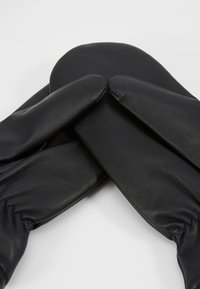 Mănuși din piele neagră cu o textură netedă, vârfuri rotunjite și un design cu încrețitură la încheietura mâinii, așezate suprapuse una peste cealaltă.
