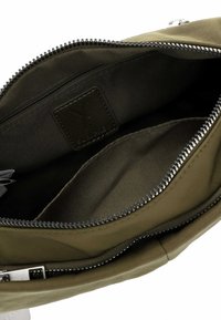 Borsa a spalla verde oliva con chiusura a zip, caratterizzata da una texture liscia e una tasca interna con etichetta. Dettagli in metallo argentato.