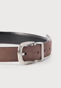 Καφέ σουέντ ζώνη με υφή, μαύρη δερμάτινη πίσω όψη, ασημένια μεταλλική πόρπη και πέντε τρύπες ρύθμισης.