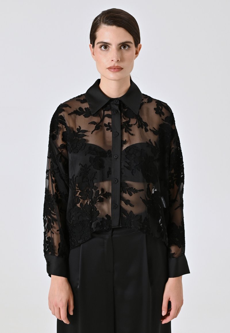 Zwarte sheer blouse met bloemenborduurwerk, lange mouwen, een kraag en een knoopsluiting aan de voorkant. Gevarieerd textiel geeft een gelaagd uiterlijk.