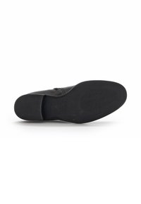 Zwarte leren schoen met een glad bovenwerk, ronde neus en een getextureerde rubberen zool met een subtiel patroon voor grip.