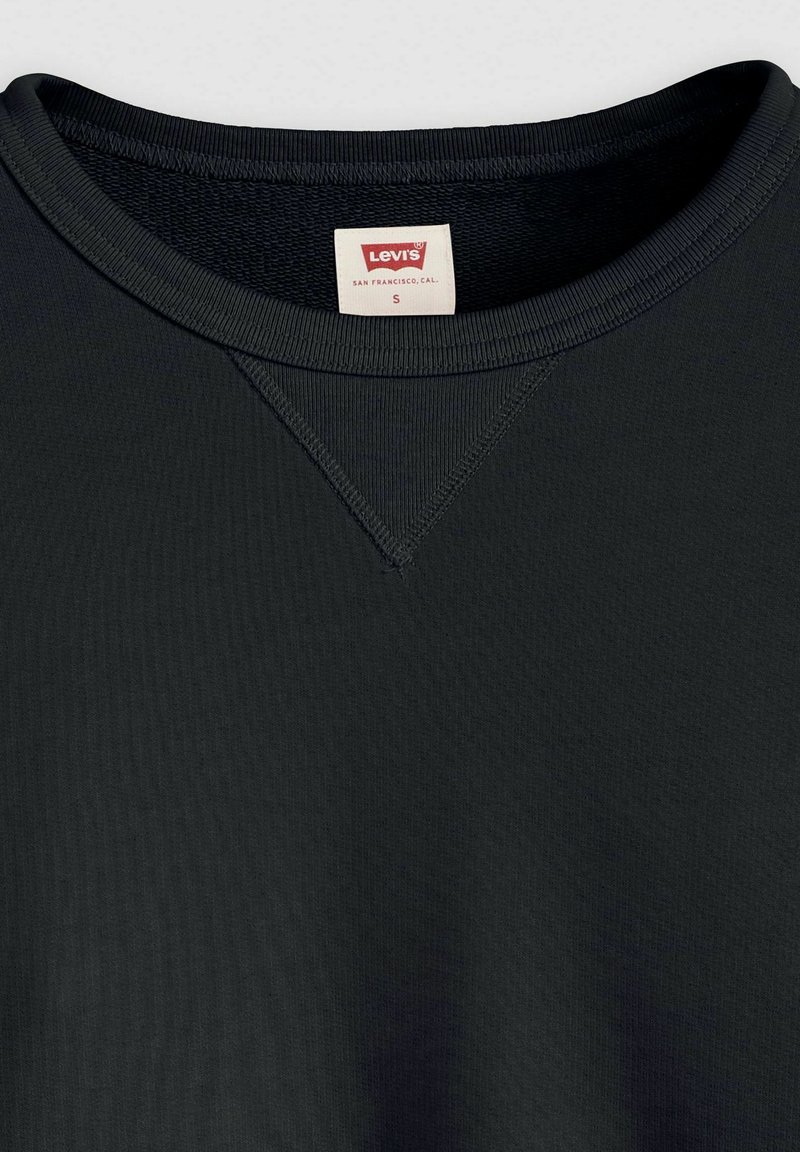 Czarna bluza z okrągłym dekoltem, wykonana z mieszanki bawełny, z prążkowaną fakturą, płaskimi szwami i małą metką z napisem "Levi's" wewnątrz kołnierza.