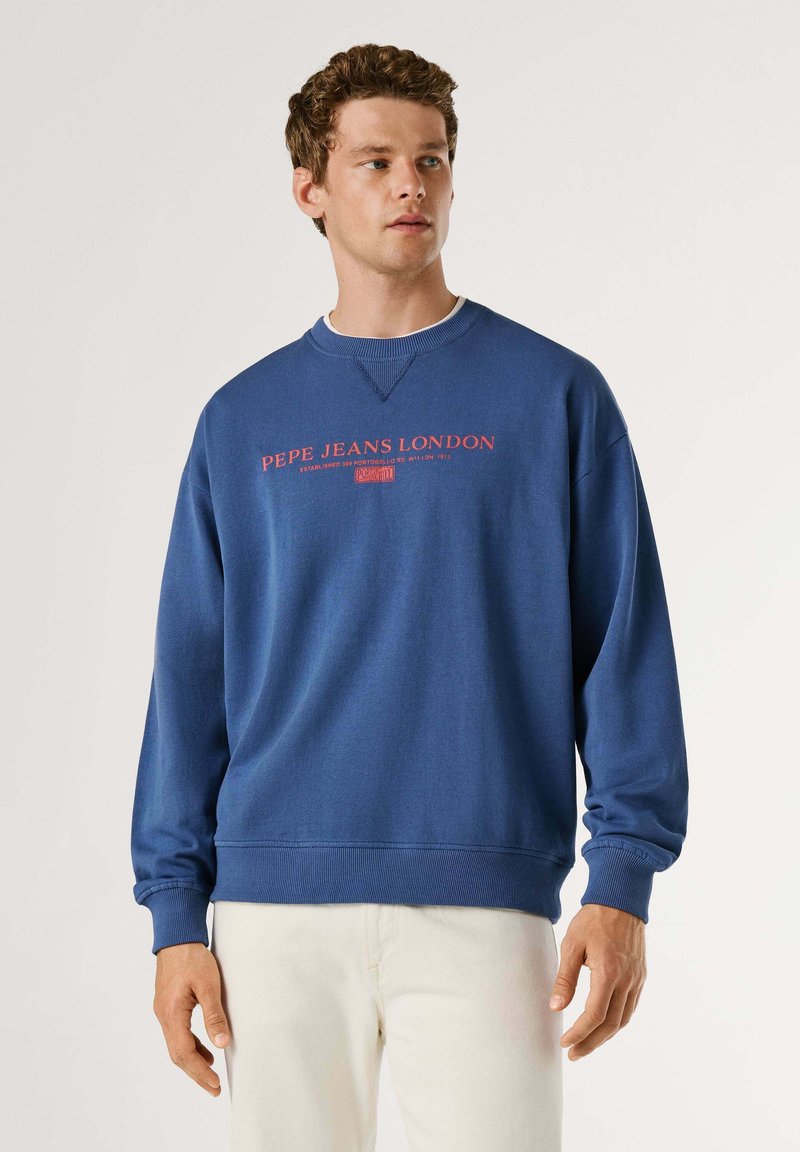 Sweat-shirt bleu en mélange de coton. Comprend un col rond et des poignets côtelés avec le logo "PEPE JEANS LONDON" en rouge sur la poitrine.