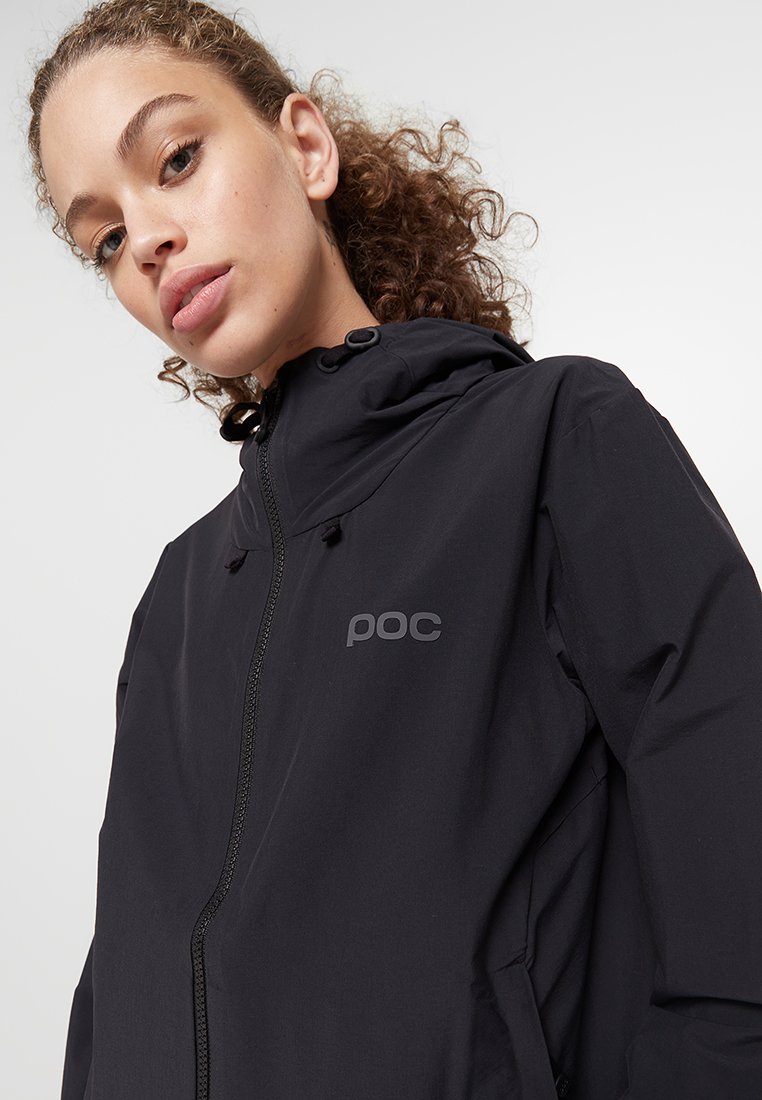 Chaqueta negra con capucha hecha de un material ligero, que presenta un cierre frontal con cremallera y un sutil logo "poc" en el pecho.