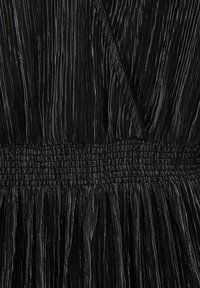 Svart klänning med en plisserad design och texturerade ränder. Midjan är resår- för att ge elastisk passform, vilket förbättrar passform och struktur.