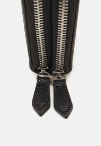 Black pouch with dual silver zippers, featuring textured black leather zipper pulls. The material appears durable with a structured design.
